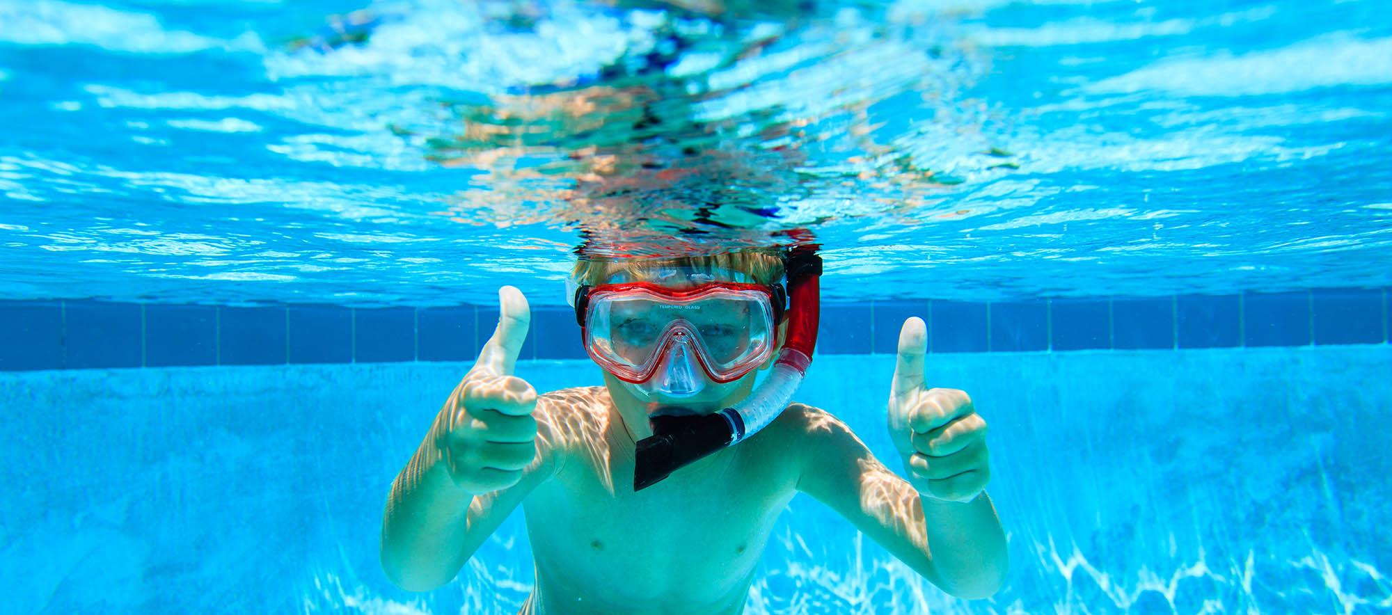 Kind met snorkel in het zwembad